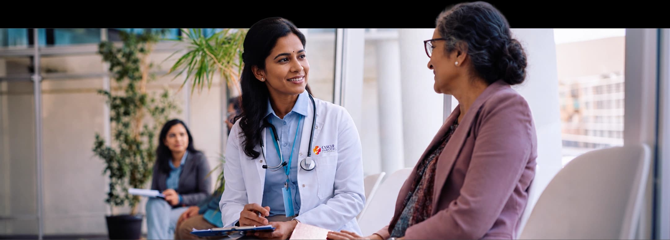 A Cancer Healer Center doctor speaking with a patient in a consultation room